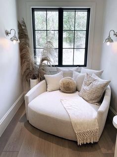 a white couch sitting in front of a large window