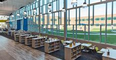 an empty library filled with lots of books and desks next to large glass windows