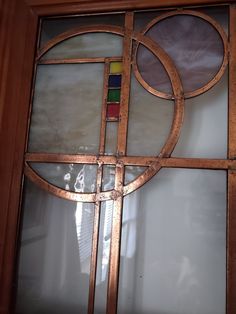 an old stained glass window with different colored circles and bars on the bottom half of it