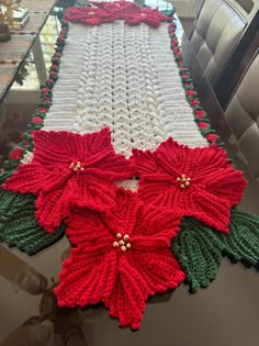 a crocheted table runner with poinsettis on it