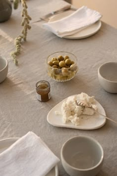 a table topped with plates and bowls filled with different types of food on top of it