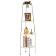 a white leaning shelf with books and pictures on the top, next to an orange vase filled with flowers