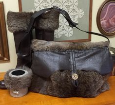 a pair of boots sitting on top of a table next to a purse and cup