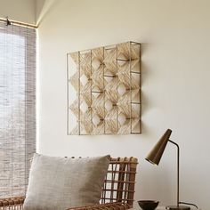 a wicker chair sitting next to a table with a lamp on top of it