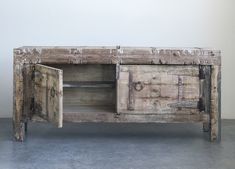 an old wooden sideboard with two doors and drawers on the bottom, one door open