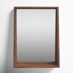 a mirror hanging on the wall next to a white wall