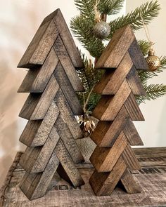 two wooden christmas trees sitting next to each other on top of a piece of wood