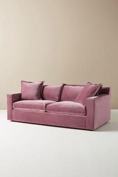 a pink couch sitting on top of a white floor