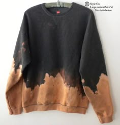 a black and brown sweatshirt hanging on a white wall