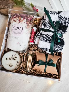 an open gift box with candles, soaps and other items in it on a table