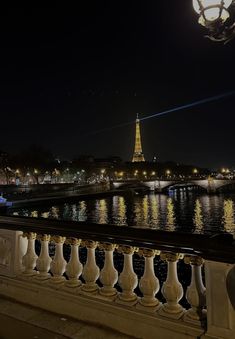 the eiffel tower is lit up in the night sky over the river seine