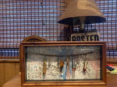 a wooden desk topped with a lamp next to a poster