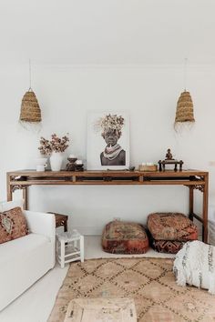 a living room filled with furniture and decor on top of a wooden table next to a white couch