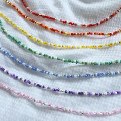 multicolored glass beads are lined up on a white cloth