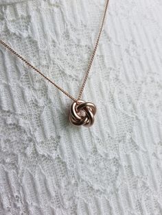 "Simple Geometric Knot Chain Pendant Necklace Chain Length: 30″  Chain Width: 1 mm Clasp: Yes Type of Clasp: Lobster Claw Pendant Length: 1/2\" Pendant Width: 1/2\" Weight: 6g Metal: Rhodium or gold plated chain, brush metal pendant, tarnish resistant, brass Options: Silver Gold Champagne (Rose Gold) Gunmetal" Rose Gold Metal Charm Necklaces, Rose Gold Round Metal Charm Necklaces, Rose Gold Metal Round Charm Necklaces, Rose Gold Round Metal Charm Necklace, Rose Gold Link Necklace, Rose Gold Metal Jewelry With Chain, Rose Gold Link Necklace With Clavicle Chain, Rose Gold Pendant Necklace With Box Chain, Rose Gold Round Chain Necklace