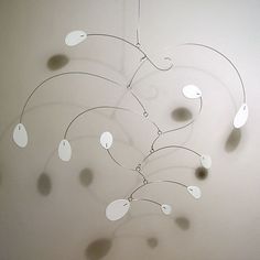 a wind chime hanging from the ceiling with lots of circles and leaves on it