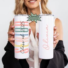 a woman is holding two personalized tumblers