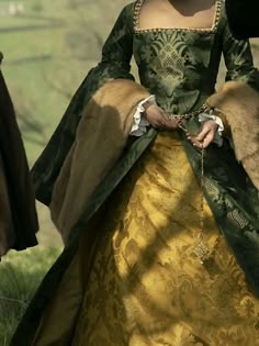 a woman in a green and gold dress