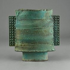 a green vase sitting on top of a table