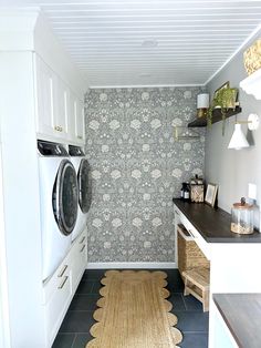 a washer and dryer in a small room with wallpaper on the walls