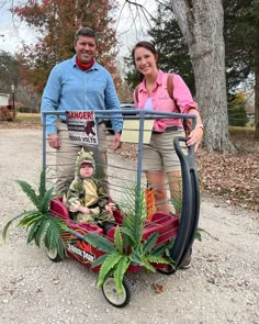 a man and woman standing next to each other in a cart with plants on it