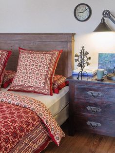 a bedroom with a bed, nightstand and clock on the wall