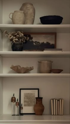 shelves with vases, books and pictures on them