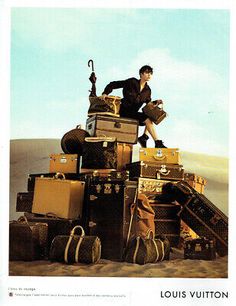 an advertisement for louis vuitton with a man standing on top of suitcases