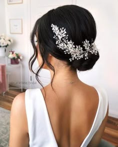 the back of a woman's head wearing a bridal hair comb with leaves on it