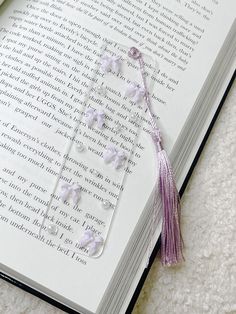 an open book with beads and tassels laying on the floor next to it