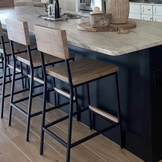 a kitchen island with four stools in front of it and an oven on the other side