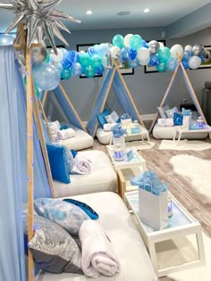 a room filled with lots of blue and white balloons