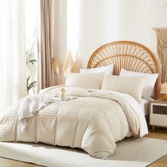 a bed with white sheets and pillows in a room next to a wicker headboard