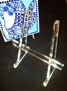 an artistic glass sculpture sitting on top of a table next to a small easel