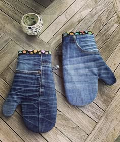 two pairs of denim mittens sitting on top of a wooden floor