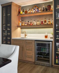 a kitchen with wooden cabinets and shelves filled with liquor bottles