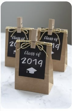 three brown paper bags with graduation tags on them