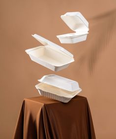 two take out containers are on top of a table with a cloth draped around them