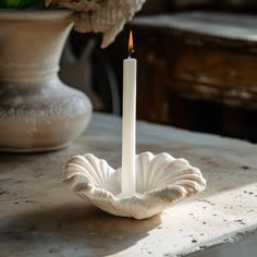 a white candle sitting on top of a table