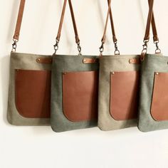 three bags hanging on the wall with leather handles