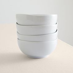 four white bowls stacked on top of each other