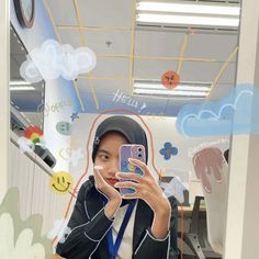 a woman taking a selfie with her cell phone in an office cubicle area