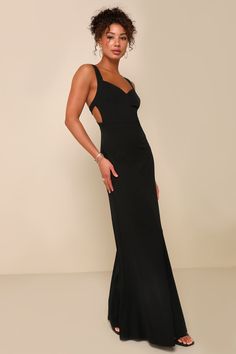 a woman in a black dress posing for the camera with her hands on her hips