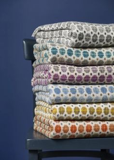 a stack of towels sitting on top of a wooden chair next to a blue wall