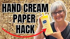 a woman holding up a tube of hand cream in front of a cracked wall with the words hand cream paper hack