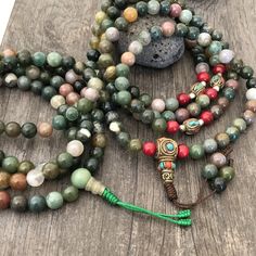 Beautiful Mix Jade Japa Mala from Nepal. You can choose between the mala that has unique mix metal beads and a main Nepali metal bead at the bottom of the mala necklace. Or the mix Jade mala that is all stone beads with no metal beads. A unique praying mala that can be used as a necklace or as an ornament. The mala has no clasp, you wear it over the head. The Mala with the metal beads and the red beads has a total length of 49cm- 19.25 inch long The mala that is all stone beads is 43cm- 17 inch Spiritual Colorful Beads Bracelet, Healing Beaded Bracelets With Round Beads, Hand-strung Multicolor Round Beaded Necklaces, Bohemian Beaded Necklaces With 8mm Beads For Jewelry Making, Bohemian Multicolor Beaded Necklace, Green Mala With 8mm Beads For Healing, Spiritual Healing Beaded Bracelets With Oval Beads, Adjustable 108 Beads For Jewelry Making, Bohemian Multicolor 8mm Beads