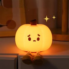 a glowing pumpkin sitting on top of a white counter next to a window sill