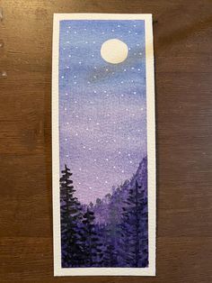 an image of a night sky with trees and the moon in the distance on a piece of paper