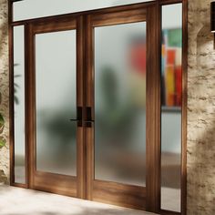 an open glass door in front of a brick wall and potted plant on the floor