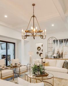 a living room with couches, chairs and a chandelier in the center